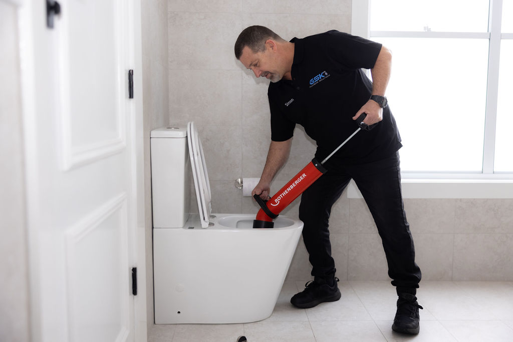 GSK Plumbing Solutions plumber clearing a blocked toilet in Sydney